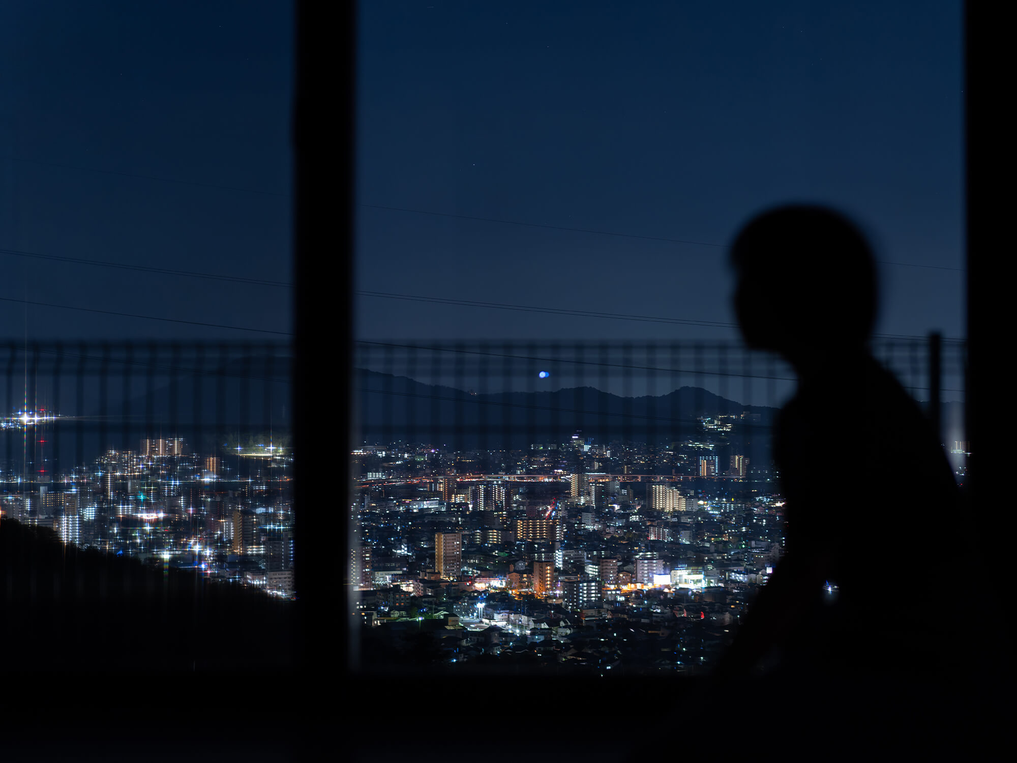 窓際のベンチから街のあかりを望む、丘の上の特等席。