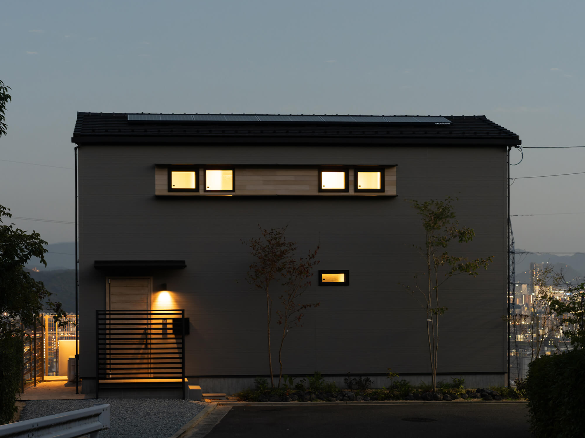 街の灯りを背に、やさしく光がにじむ外観。プライバシーと夜景を両⽴した設計です。