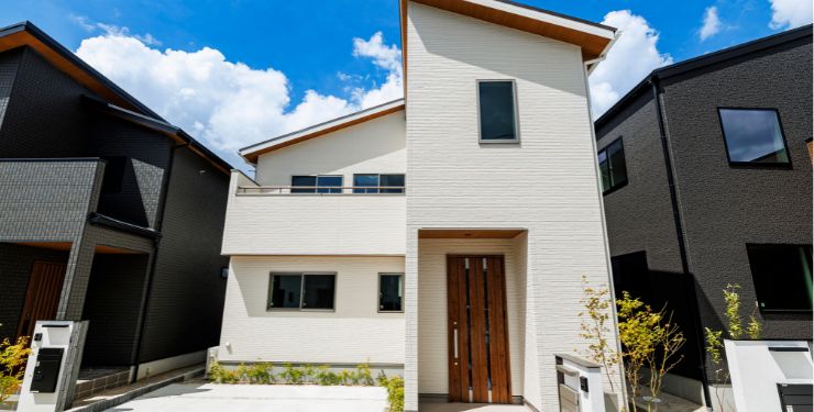 白いカラーと縦に長いドアが特徴の分譲住宅