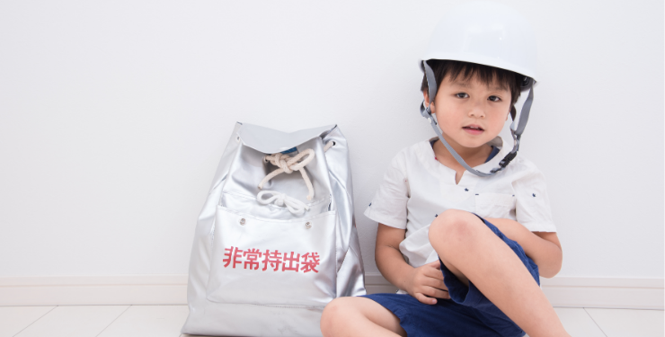 非常持ち出し袋と並んで座っている子ども