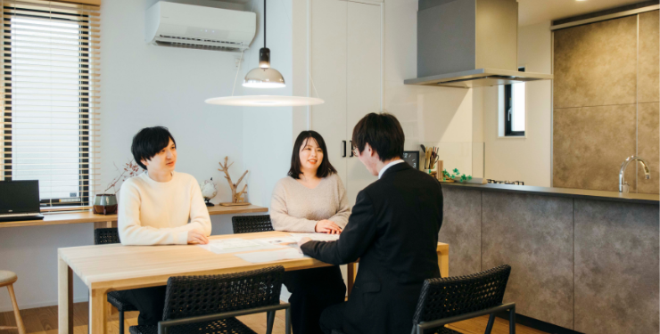 夫婦と営業スタッフが会話をする風景