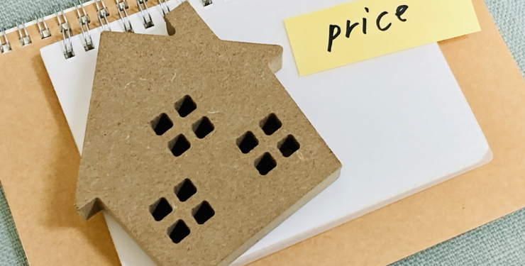 家の模型とpriceと書かれた付箋がノートの上に置かれている