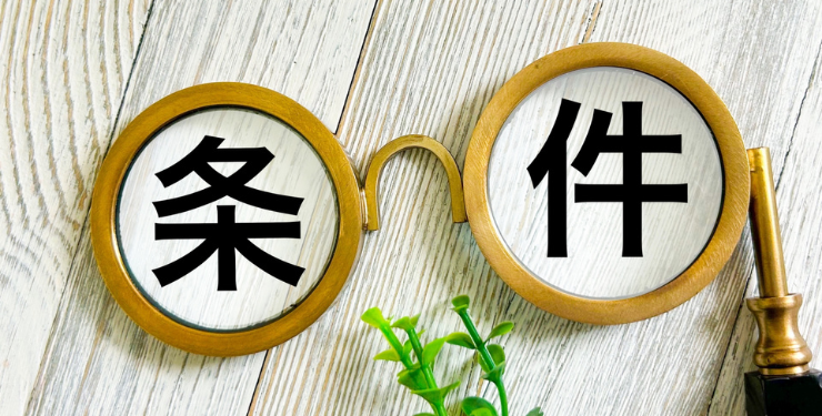 机の上に置かれた眼鏡の中に条件と書かれた文字が置かれている