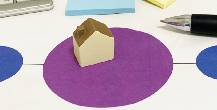 紫の円の中に家の模型が置かれている
