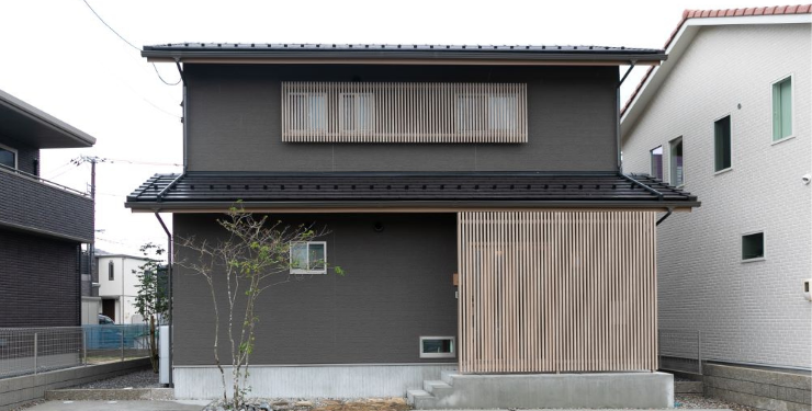 黒い外壁と木の桟が印象的な住宅