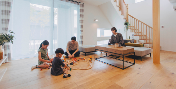 リビングで子どもと遊ぶ家族
