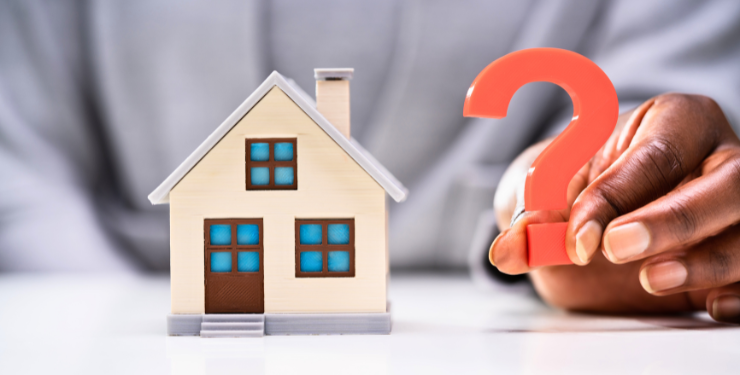 家の模型の隣に赤いクエスチョンマークが置かれている