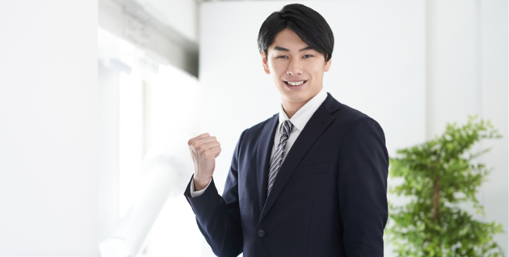ガッツポーズをするスーツ姿の男性
