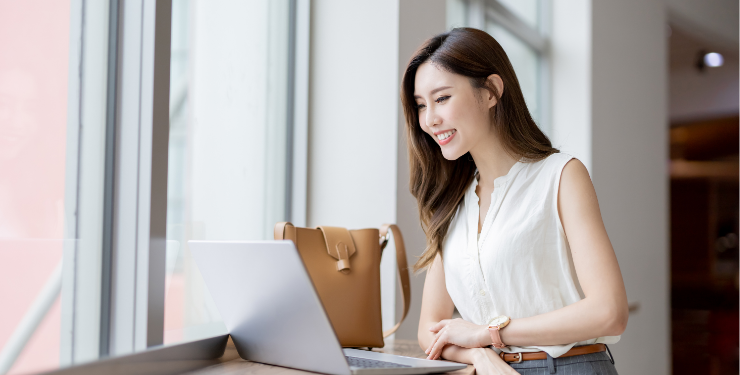 窓際でパソコン作業をする女性