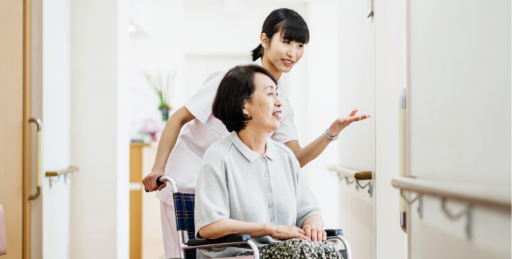 車いすの女性とそれを介助する人