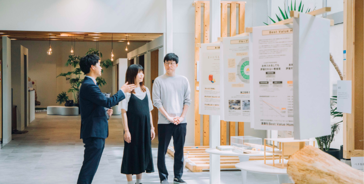 住宅ショールームで営業マンと話す夫婦