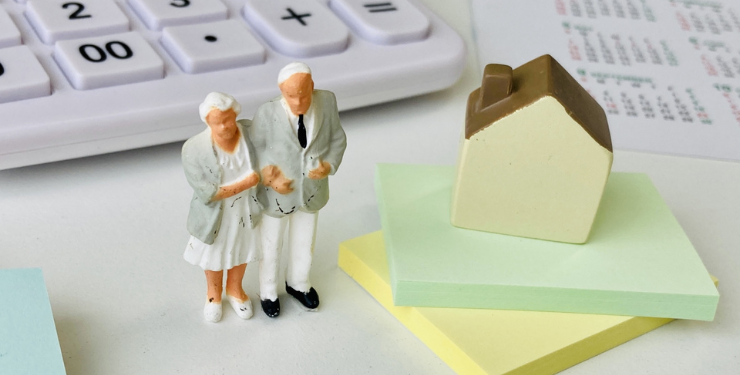 老夫婦のフィギアの周りに家と付箋と電卓が置かれている