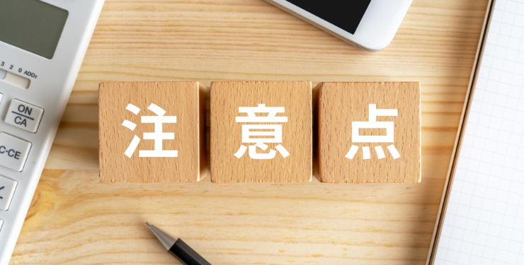 机の上に注意点と書かれた木製キューブと電卓が置かれている