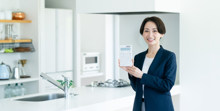 女性が電卓を持ってキッチについて説明している様子