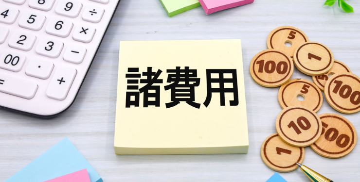諸費用と書かれたポストイットの周りに電卓とおもちゃのお金が置かれている
