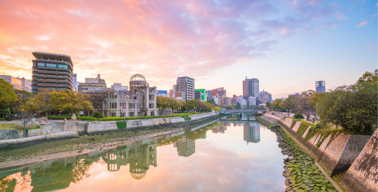 大きな河の両側に建物が並び、水面に夕焼けが反射している様子
