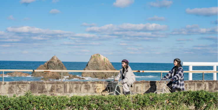 海沿いをサイクリングする女性たち