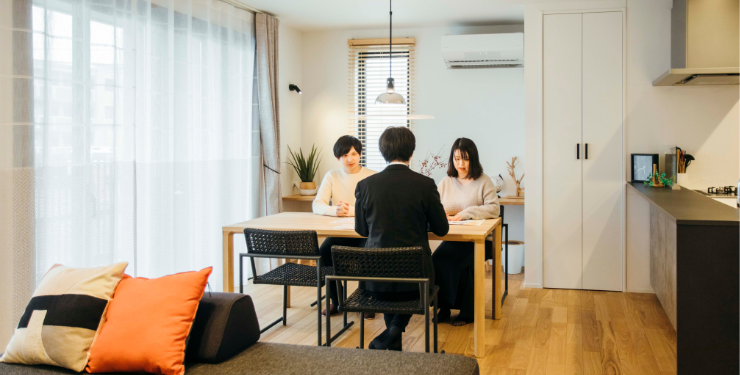 住宅にて営業マンと夫婦が話している様子