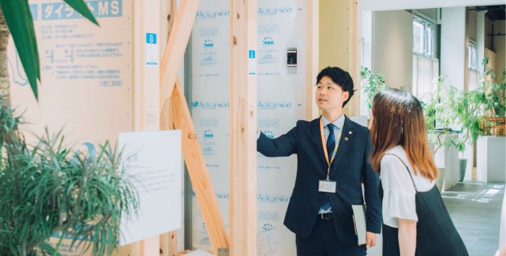 住宅営業マンが住宅基礎について説明しそれを聞く夫婦