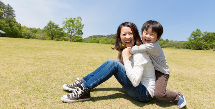 公園で笑顔でじゃれあう親子