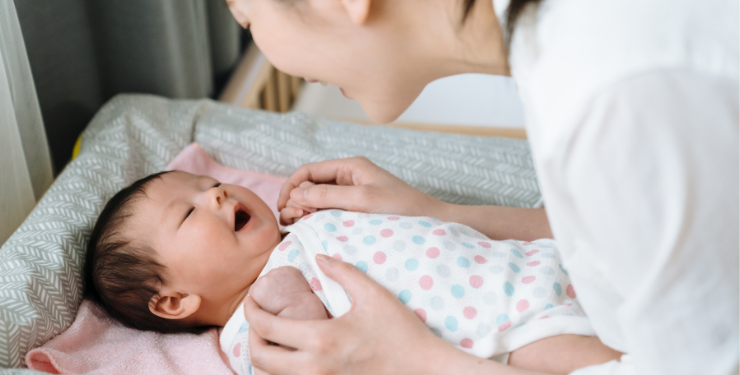 笑顔で向かい合っている赤ちゃんと母親