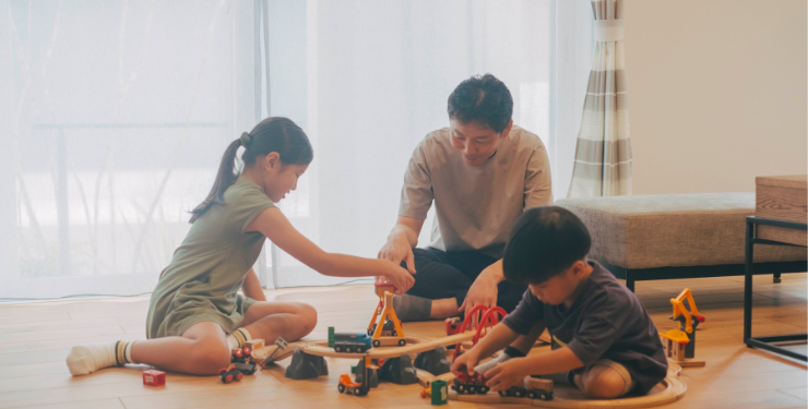 リビングで子供と一緒に遊ぶお父さん