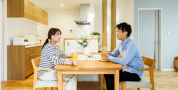 ダイニングにて向かい合って話し合う夫婦