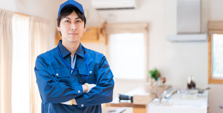 点検済の家の中で業者の男性が腕を組んでいる様子