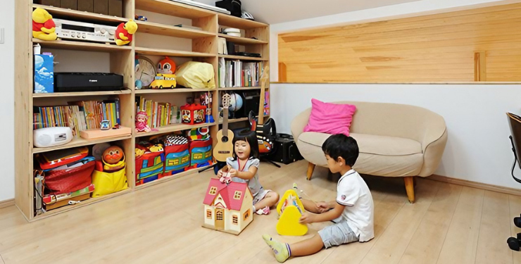 大きい本棚が特徴的な子ども部屋で兄妹が遊んでいる様子