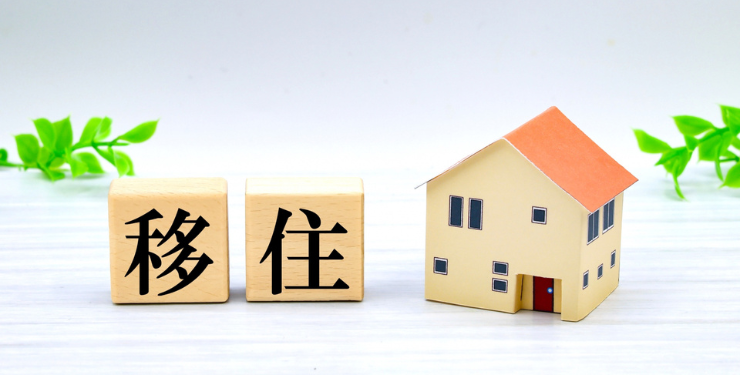 家の模型の横に移住と書かれた木製サイコロが置かれている