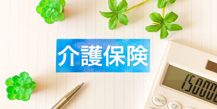 介護保険と書かれた文字の周りに葉っぱと電卓が置かれている