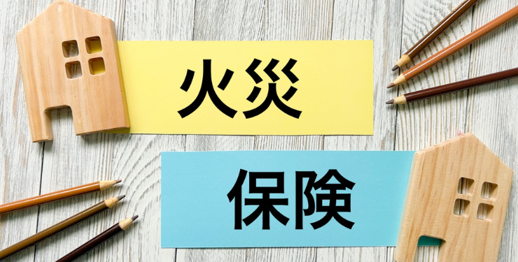 火災保険と書かれたポストイットの周りに家のパネルと鉛筆が置かれている