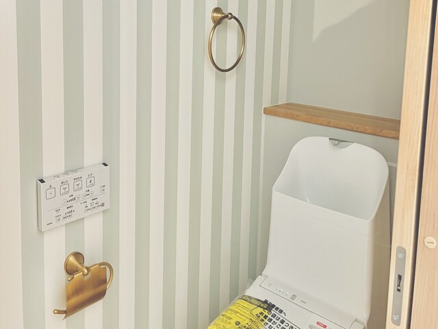トイレも可愛らしいクロスにおしゃれな紙巻き器とタオル掛けによって雰囲気がほんわか