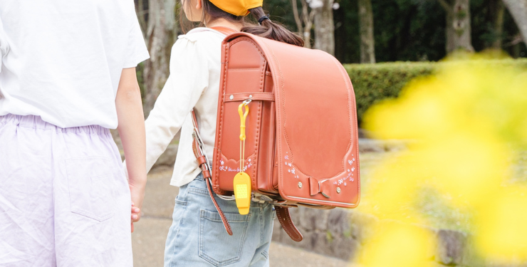 女の子が赤いランドセルを背負って姉と一緒に通学している様子