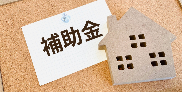 コルクの家型パネルの横に補助金と書かれたメモが置かれている