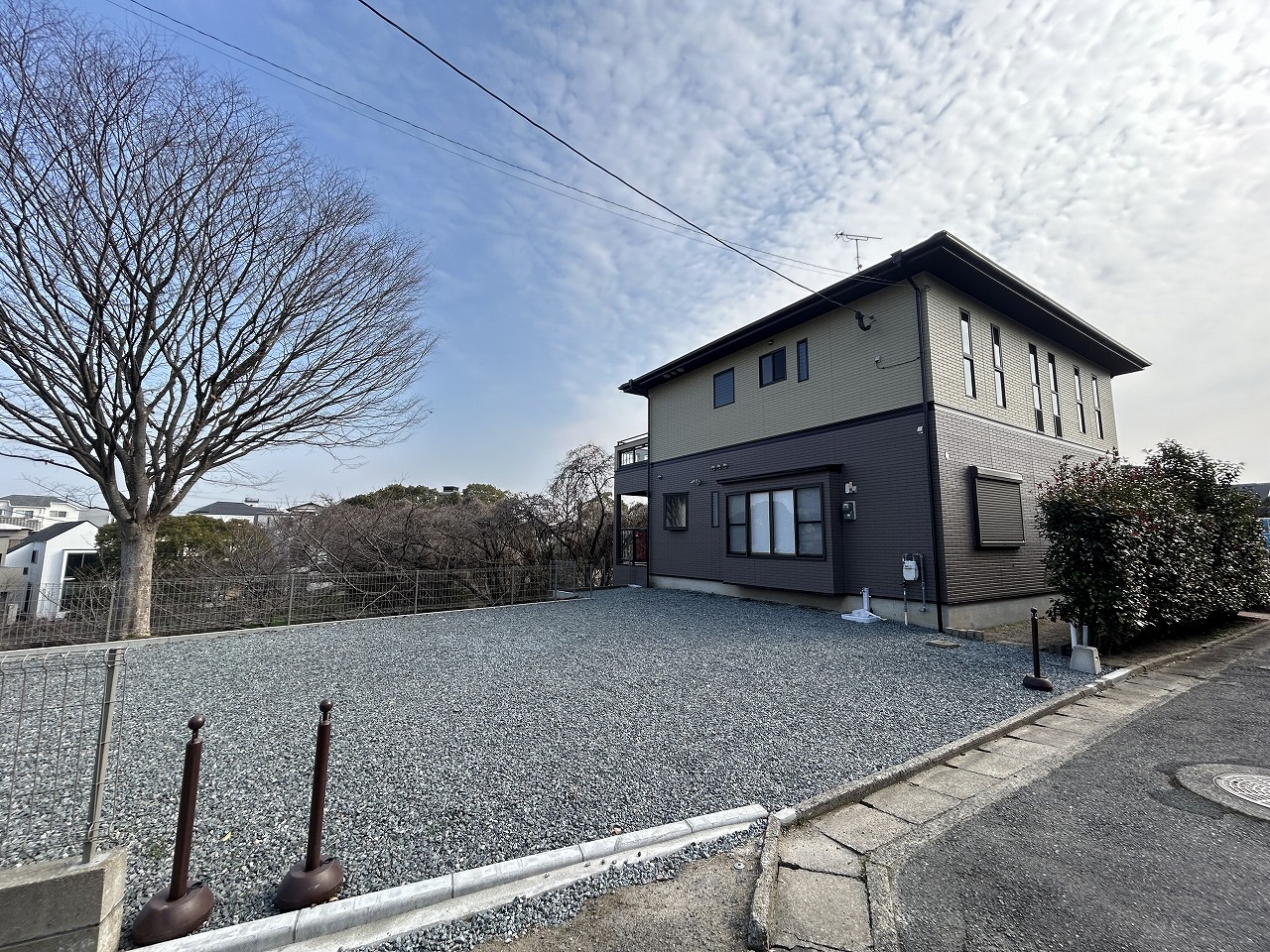 二階建ての住宅と広い駐車場