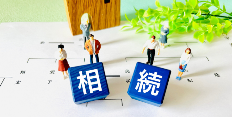 家系図の上に相続と書かれたブロックの周りに家族のフィギアが置かれえいる