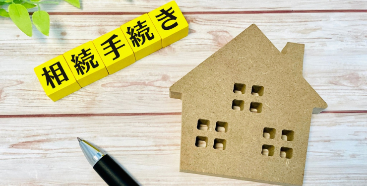 相続手続きと書かれたパネルの隣に家のコルクパネルが置かれている