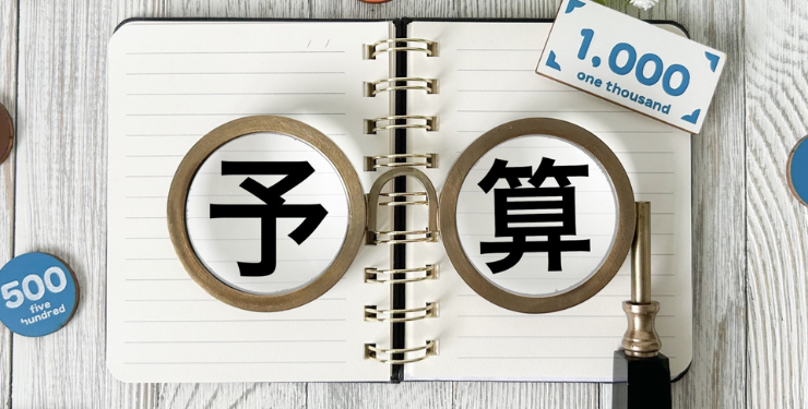 ノートの上に予算の文字があり、眼鏡が置かれている