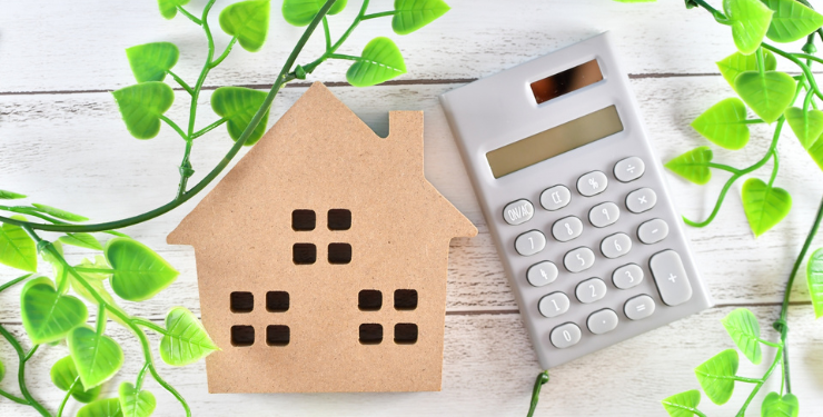 机の上に家の木製パネルと電卓が置かれている