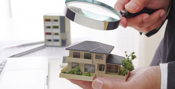 不動産の模型を虫眼鏡で見てる様子