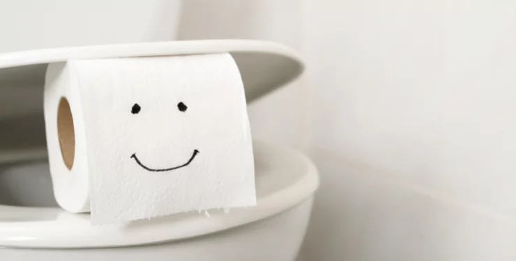 洋式トイレに挟まれている、似顔絵が描かれたトイレットペーパー