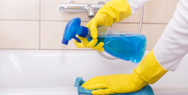 浴槽を洗剤と布巾で清掃している